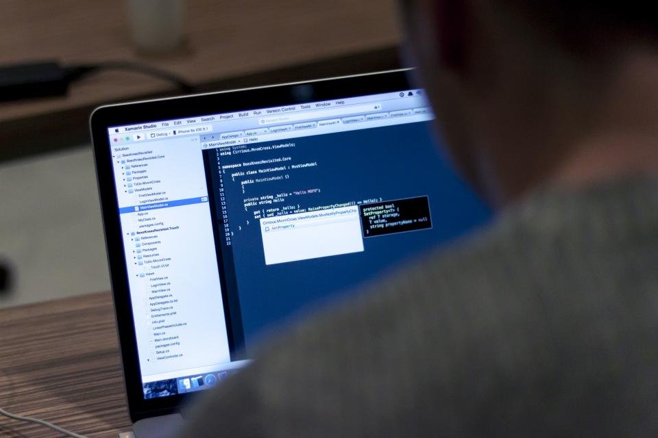 Salesforce developer writing code on a laptop